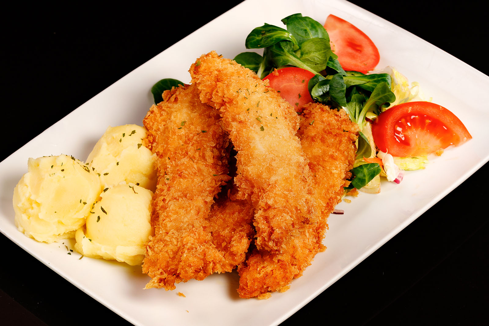 Pankómorzsás, joghurtos csirkemellcsíkok burgonyapürével és kevert salátával